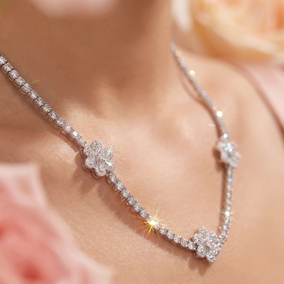 A close-up lifestyle shot of a diamond necklace worn on a model's neck, featuring three floral clover motifs on a delicate chain, framed by soft pink roses.